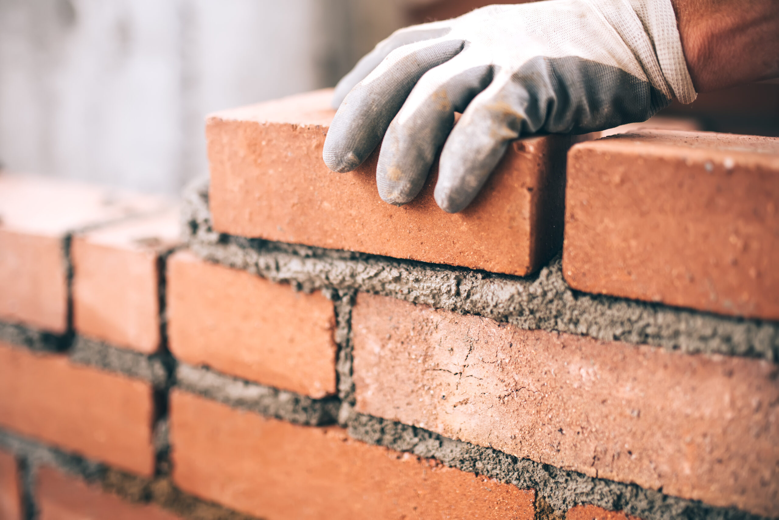 Close,Up,Of,Industrial,Bricklayer,Installing,Bricks,On,Construction,Site